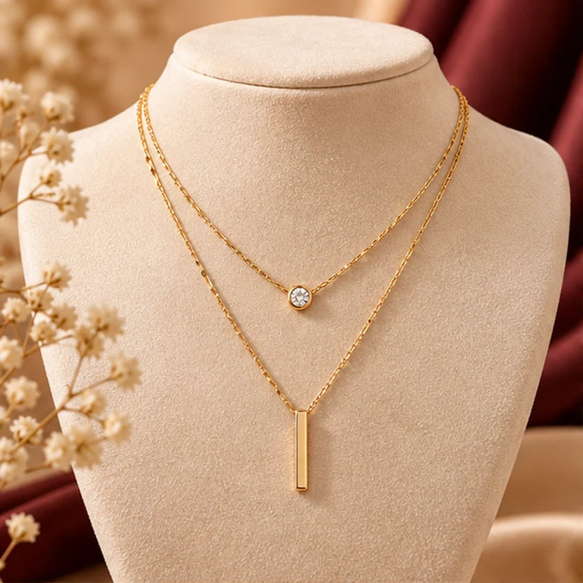 Editorial preview of layered gold-tone pendant necklace on jewelry bust